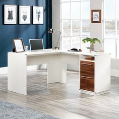 an office with blue walls and white furniture