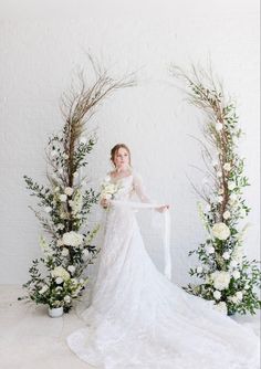 a woman in a wedding dress standing next to flowers