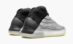 The adidas Yeezy QNTM “Quantum” is the lifestyle variation of Kanye West’s signature look inspired by performance basketball silhouettes.  Designed as an off-court option, the “Quantum” features reflective detailing not found on the performance basketball-aligned edition.  The upper features a two-tone Primeknit pattern similar to the Yeezy Boost 350 V2.  An extended ankle collar provides superior protection and stability.  Elsewhere, a tan suede overlay on the toe provides additional styling. Yeezy Quantum, Basketball Silhouette, Lifestyle Model, Black Slippers, Baskets Adidas, Adidas Boost, Exclusive Sneakers, Nike Dunk High, Nike Shox