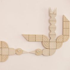 a sculpture made out of wooden pieces on a white wall