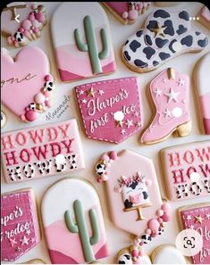 decorated cookies with pink and white frosting are arranged on a table top in the shape of cactuses