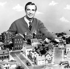 a black and white photo of a man standing in front of a city