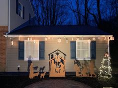 a house decorated for christmas with lights and decorations on the front porch, including a nativity scene