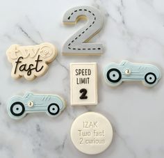 cookies with numbers and cars on them sitting on a marble countertop in front of a sign that says fast 2 speed limit