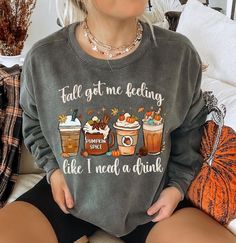 Celebrate the cozy coffee flavors of fall with this fun and cozy sweatshirt. Featuring a playful row of seasonal coffee lattes, the cheeky text, "Fall got me feeling like I need a drink" captures the essence of the season, making it a must-have for anyone who loves fall, Halloween, and, of course, coffee! Comfort Colors 1566 Sweatshirt Details: *Luxurious comfort and style are what this unisex, garment-dyed sweatshirt is all about. It's made with 80% ring-spun cotton and 20% polyester and the fa Cute Cozy Fit Tops For Fall, Relaxed Fit Coffee Color Tops For Fall, Coffee Colored Tops With Letter Print For Fall, Coffee Letter Print Tops For Fall, Coffee Long Sleeve Top With Letter Print, Coffee Color Long Sleeve Top With Letter Print, Casual Coffee Long Sleeve Sweatshirt, Casual Long Sleeve Coffee Sweatshirt, Fall Coffee Cotton Sweatshirt