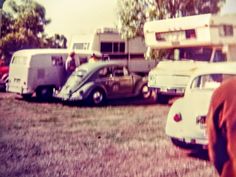 an old photo of some cars parked in a field