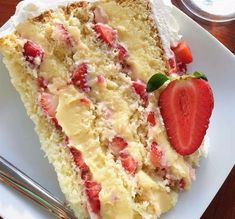 a piece of cake with strawberries on top is sitting on a plate next to a fork