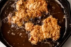 some food is cooking in a skillet on the stove top and ready to be eaten