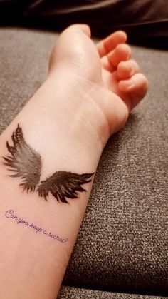 a person with a tattoo on their arm that has an angel wing and the words congratulations to someone