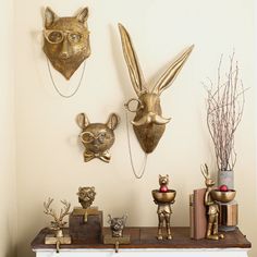 three metal animal heads are on the wall next to other decorative items and decor pieces