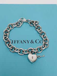 Authentic TIFFANY&Co chain link bracelet with heart and key lock removable charm in Sterling Silver. .Lock opens and closes. Marked : TIFFANY&Co.925.Condition: PRE-OWNED/ Sterling Silver shows some sight of wear.This Item does not come with original TIFFANY&Co box/pouch. Tiffany’s Charm Bracelet, Tiffany And Co Lock Bracelet, Tiffany And Co Heart Tag Bracelet, Tiffany Charm Bracelet, Tiffany Lock Bangle, Tiffany And Co Heart Lock Necklace, Tiffany And Co Box, Pandora Bracelet Charms Ideas, Tiffany And Co Jewelry