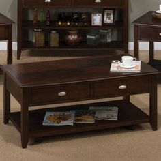 a coffee table with two end tables and a book shelf in the corner next to it