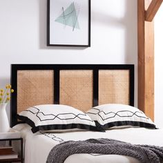 a bed with black and white pillows on top of it