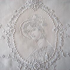 an embroidered piece of cloth with a woman's face on it