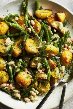 a white plate topped with green beans and potatoes