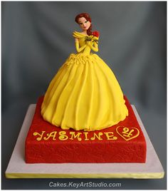 there is a cake that looks like a princess on top of the cake, and has been made to look like it's from beauty and beast