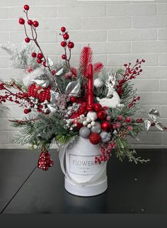 a white bucket filled with red and silver christmas decorations on top of a black table