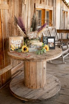 a wooden table topped with pictures and flowers on top of a wooden floor next to chairs