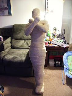 a woman in a white dress standing next to a couch