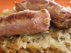 two sausages on top of some sauerkraut