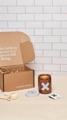 an open box with some candles and other items on a table next to the box