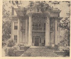 an old black and white photo of a large house with stairs leading up to the front door