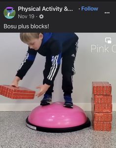 a young boy balances on a pink ball