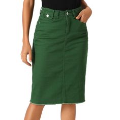 a woman is wearing a green skirt and black shirt with her hands on her hips