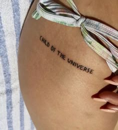 a woman's thigh with the words child of the universe written on her side