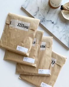 three packages of coffee sitting on top of a table next to a cup and saucer