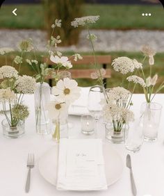 there are many vases with flowers in them on top of the table at this wedding reception