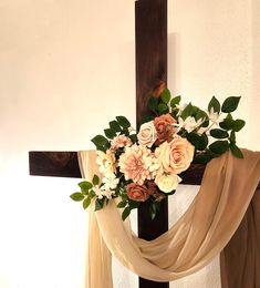 a cross decorated with flowers and greenery