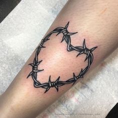 a tattoo on the leg of a person with barbed wire around it