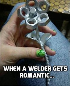 a person holding a metal object with the words, when a welder gets romantic