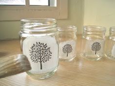 there are many jars with designs on them and one has a tree painted on it