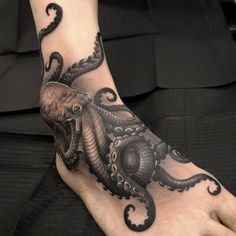 an octopus tattoo on the foot of a person with black ink and white ink,