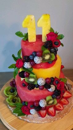 a cake with fruit on top and the number one made out of watermelon