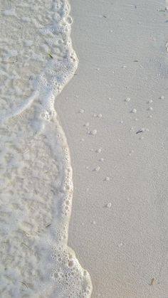 footprints in the sand and water at the beach