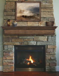 a fire place with a painting on the wall