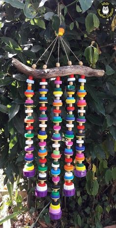 a colorful wind chime hanging from a tree branch