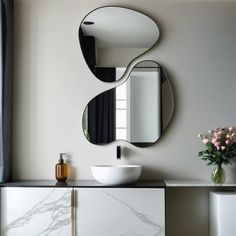 a bathroom with a sink, mirror and vase