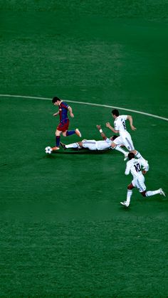 three soccer players colliding for the ball during a game