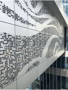 the wall is decorated with black and white dots in an office building's lobby