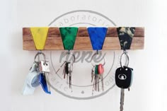 a wooden key rack with six keys hanging from it's sides and four different colors