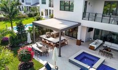 an aerial view of a house with a swimming pool and patio in the foreground