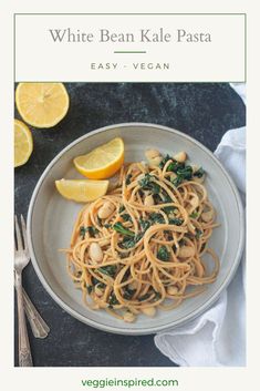 white bean kale pasta on a plate with lemon wedges