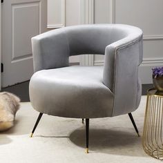 a grey chair sitting on top of a white rug