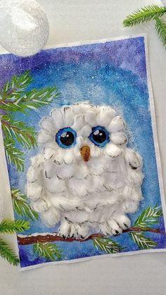 an owl is sitting on a tree branch with blue eyes and white fur around its neck