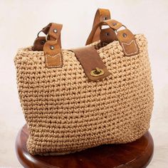 This casual, versatile shoulder bag from Mexico's Monserrat Dominguez is one you'll reach for again and again. The bag is crocheted by hand from polyester yarns in a neutral straw color, and trimmed with rugged brown leather. The tote-style handbag features a spacious inside pocket and a leather flap with a twist lock closure. Crochet Shoulder Bag, Leather Accents, Polyester Yarn, Furniture Ideas, Hand Crochet, Handbag Accessories, Tote Handbags, Inside Pocket, Straw Bag