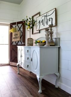 a white cabinet sitting on top of a hard wood floor next to a wooden door